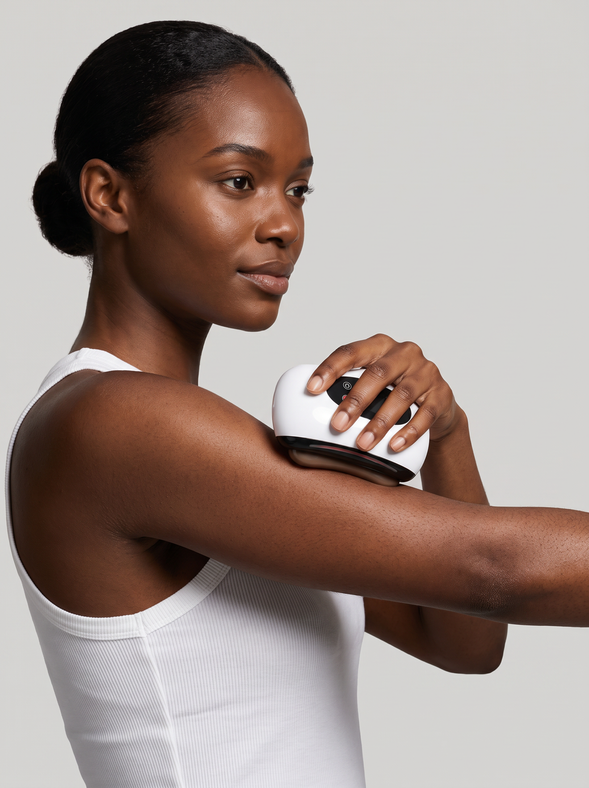 Woman using the Electric Gua Sha Tool on her shoulder